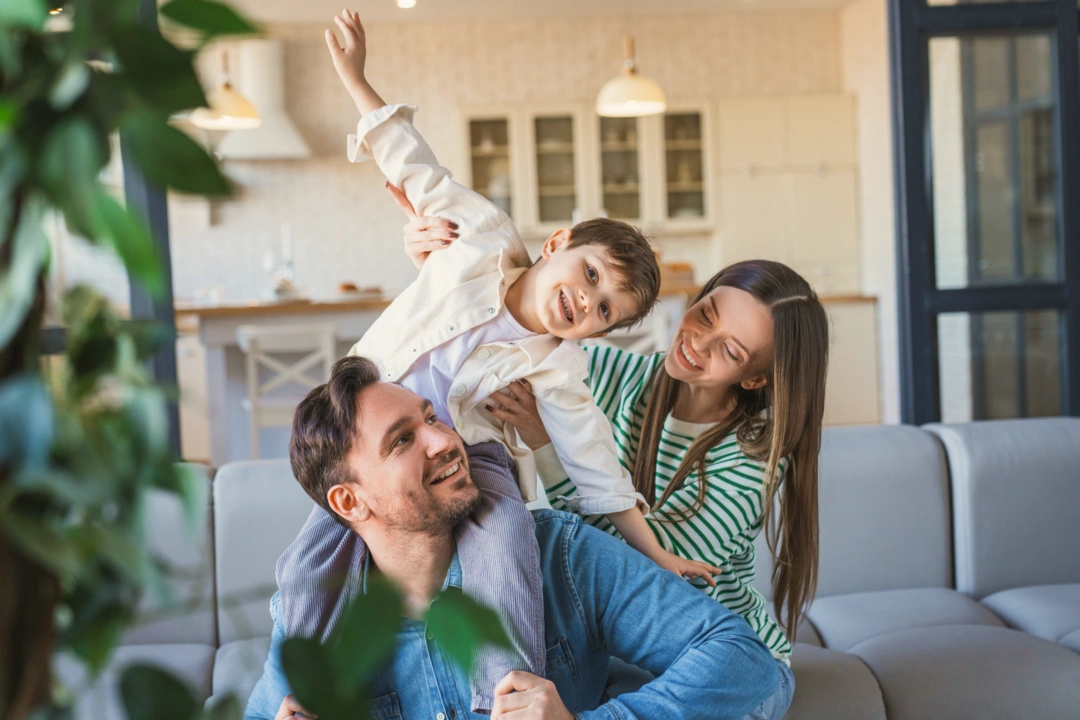 Modernes Wohnzimmer mit hellem Sofa, Holzboden und Zimmerpflanze — gepflegte Immobilie betreut durch Wohnfit Hausverwaltung